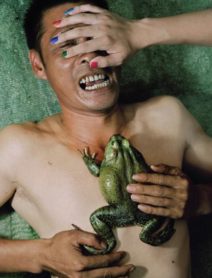 person with frog on chest with hand covering eyes