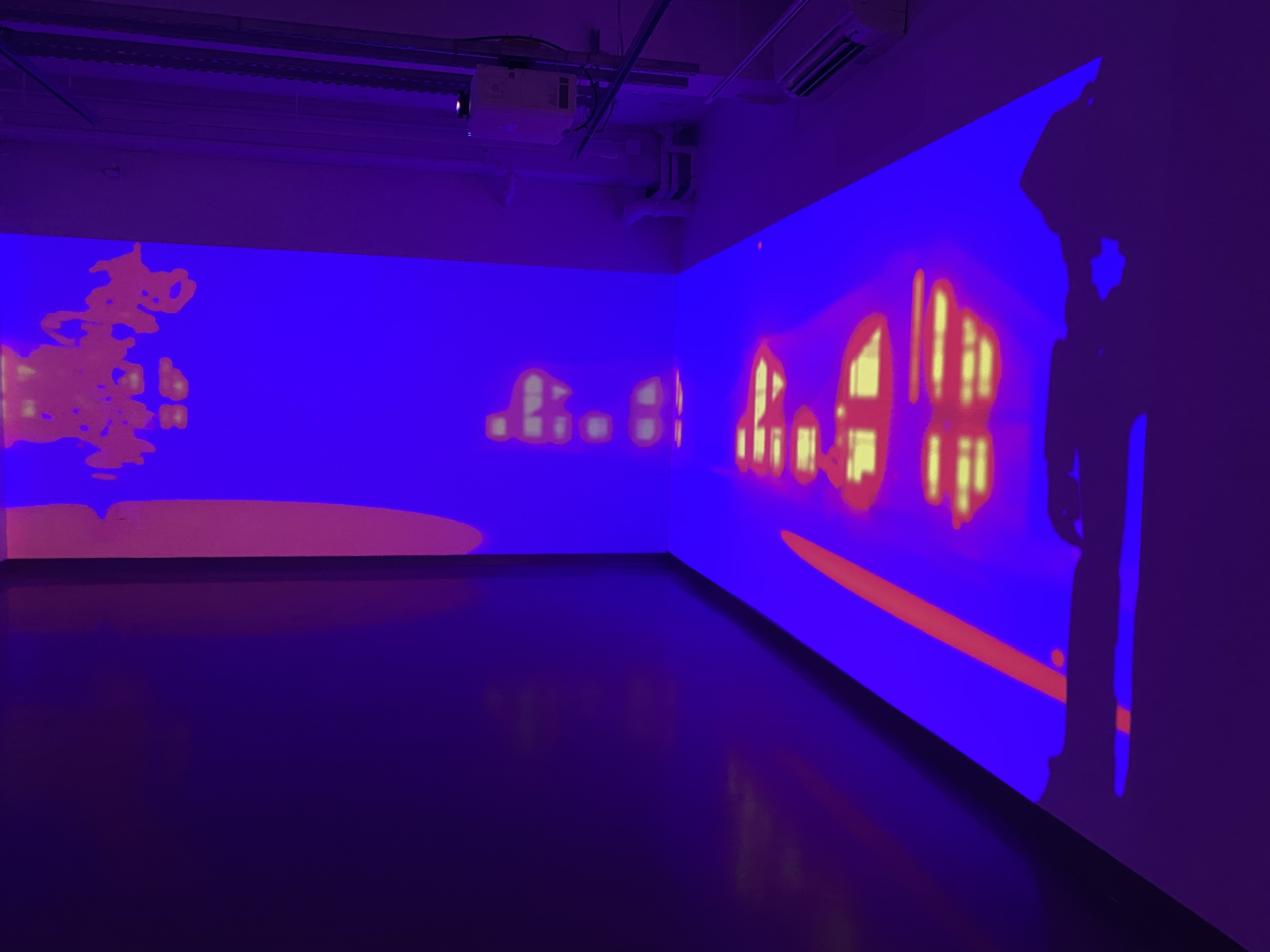 Dark gallery with immersive Single channel video projection in saturated colors.
